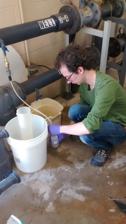 ISWS Employee Devin Mannix takes a well sample for water quality analysis, 2015