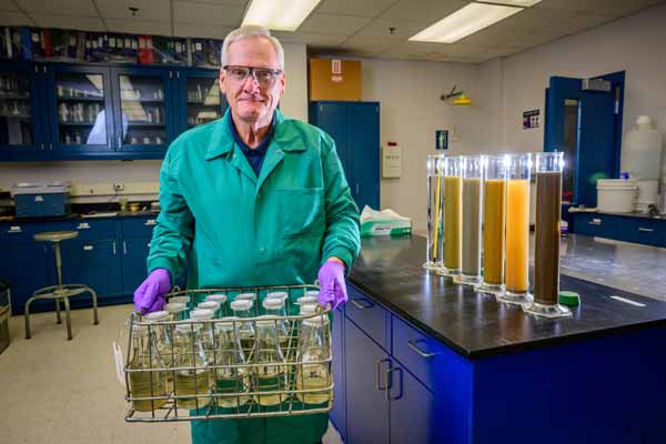 John Bearsdley holds rack of water samples.